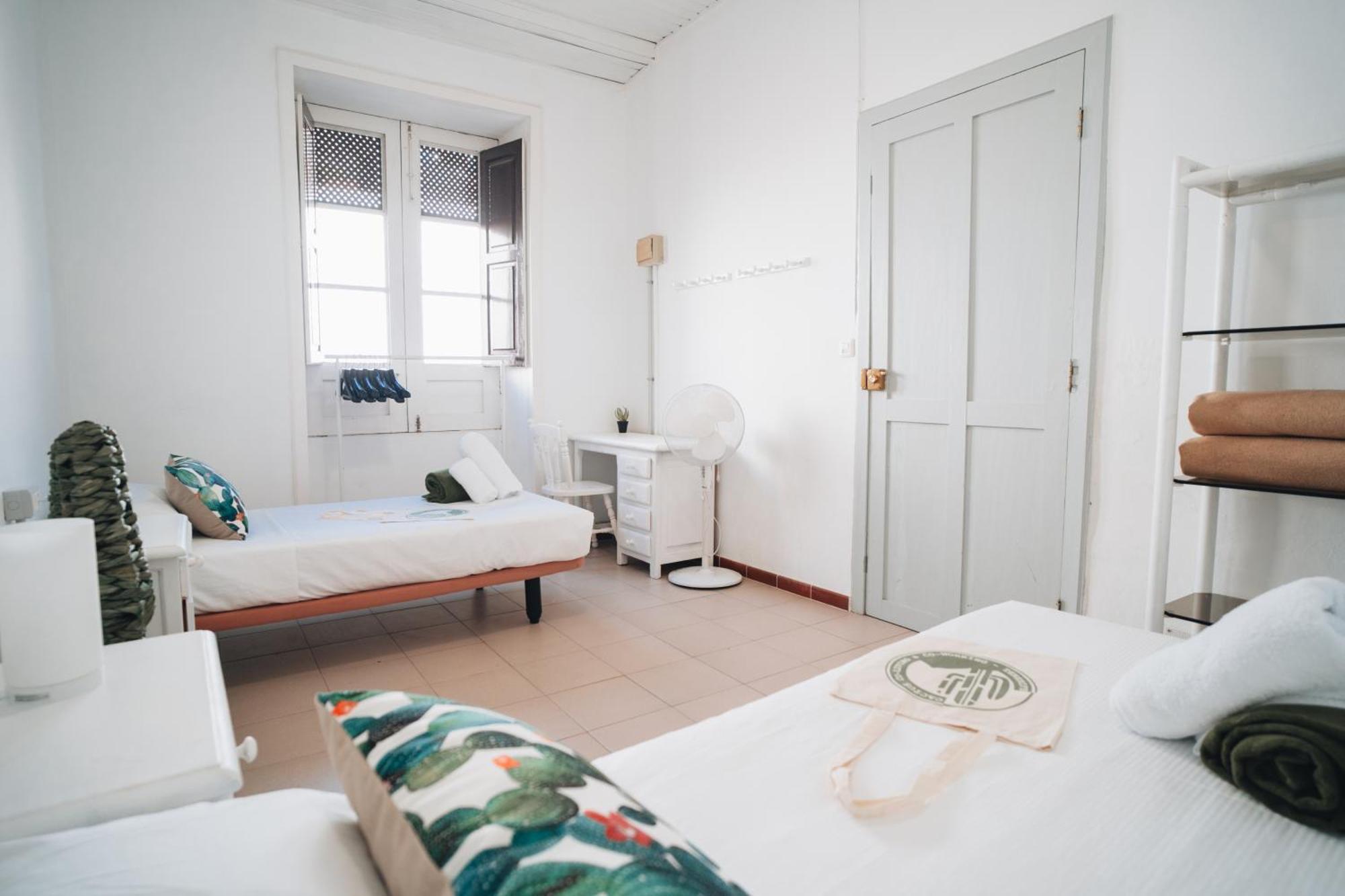 Cama individual en habitación compartida masculina, equipada con baño compartido.